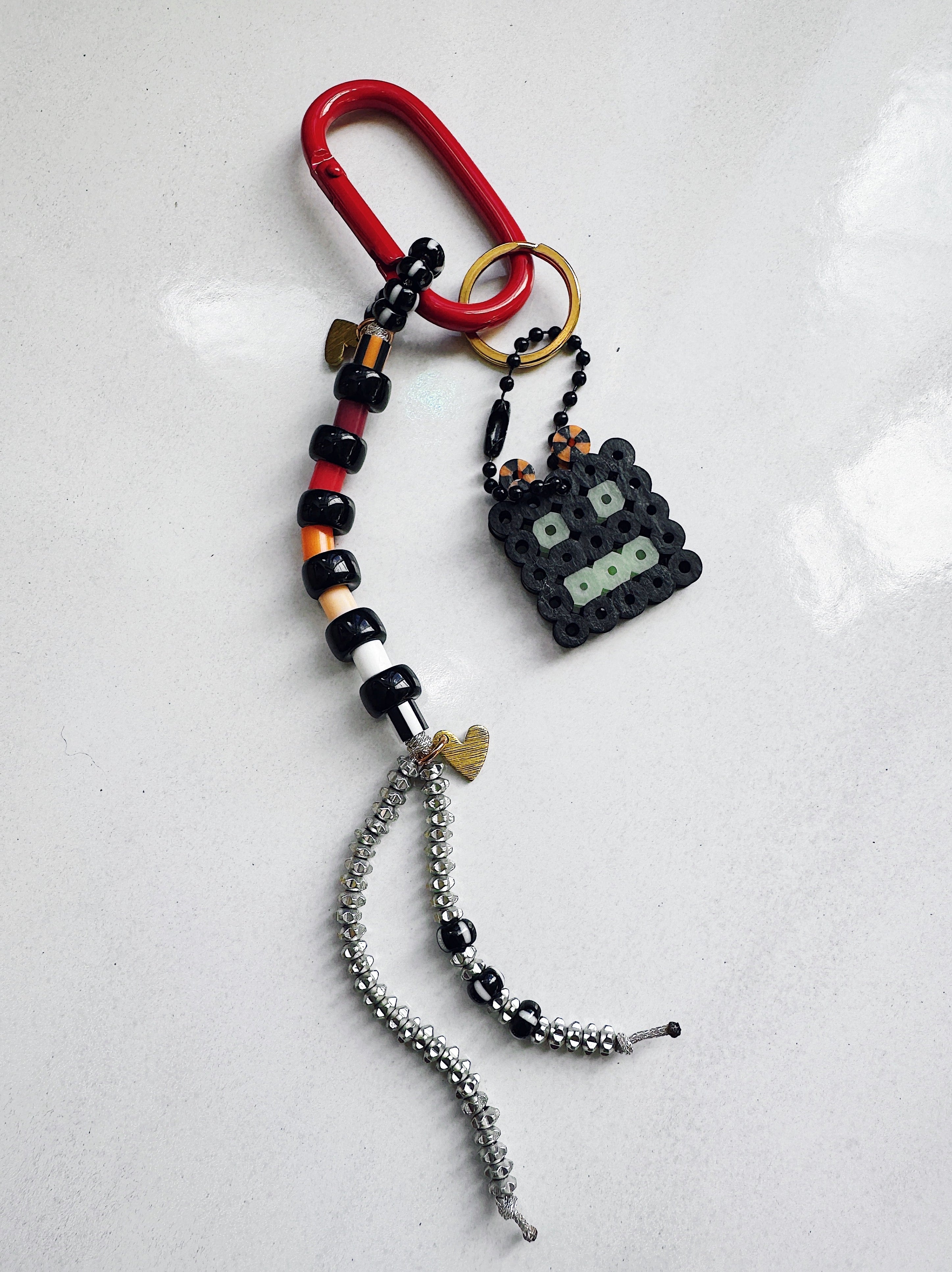 Keychain with beads and a small robot figure on a white background